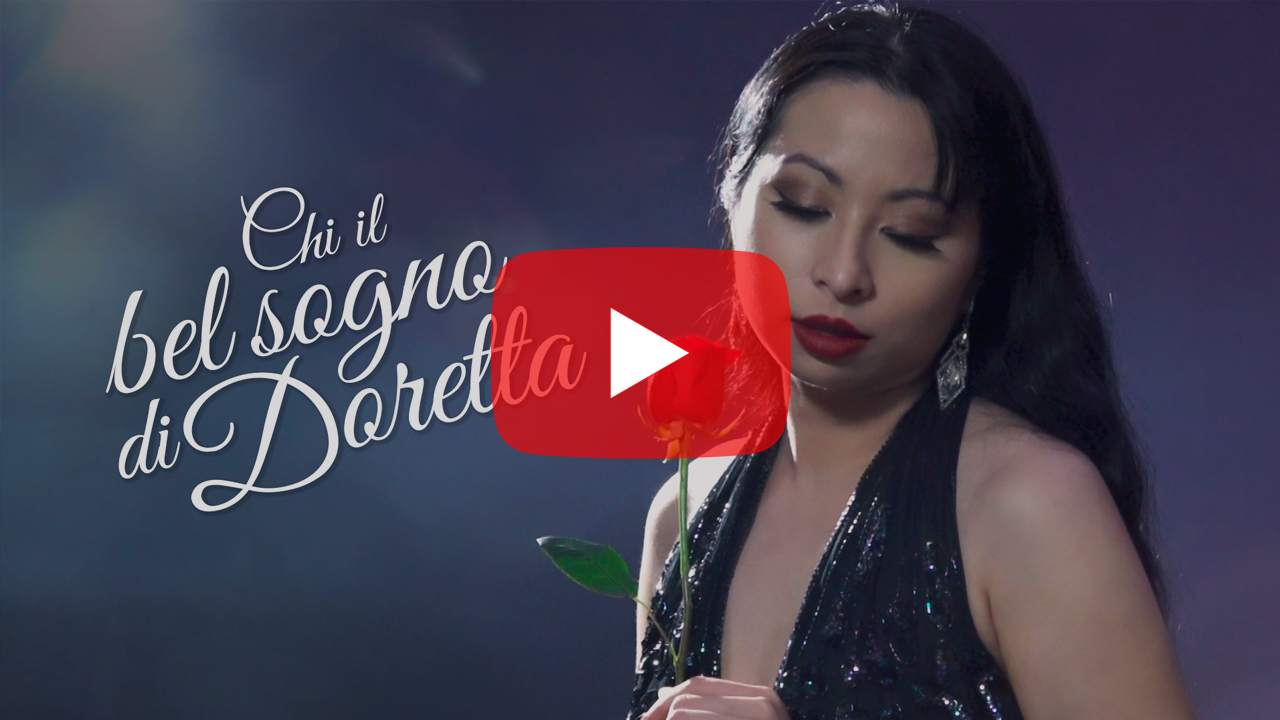 YouTube video thumbnail of Chinese-Canadian performer Jacqueline Ko with downcast eyes, holding a red rose against an artistic purple background. Cursive text reads, Chi il bel sogno di Doretta.