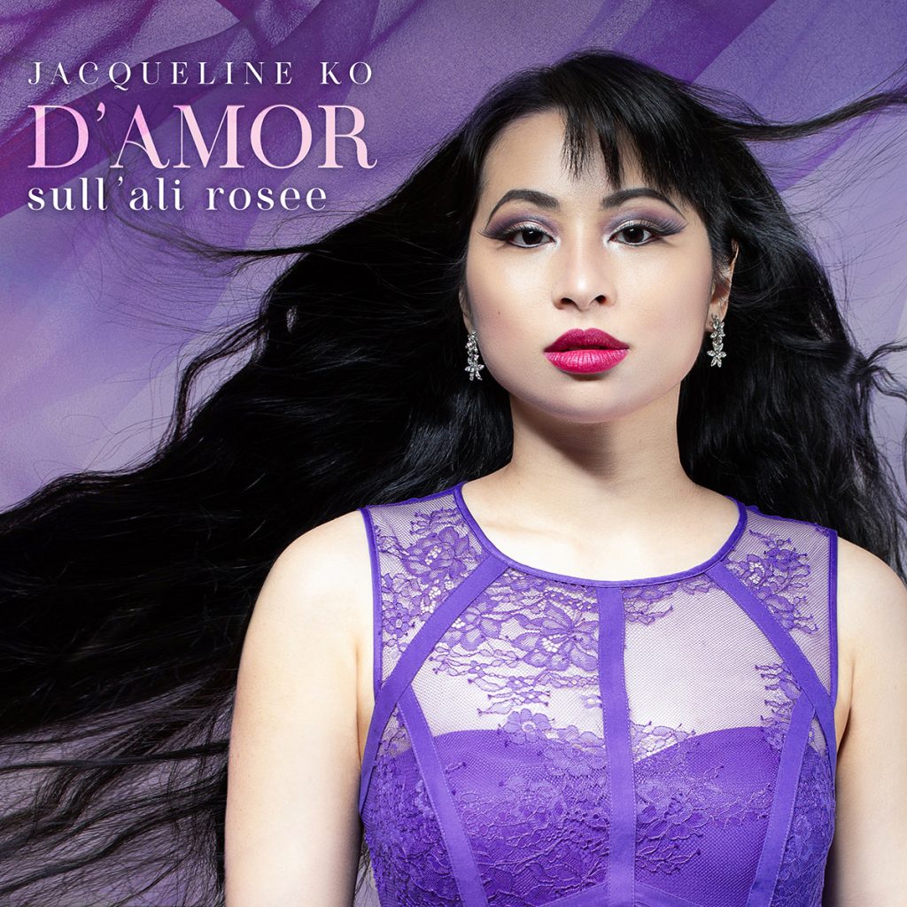 Album cover featuring a closeup of a Chinese-Canadian woman with glamorous makeup, wearing a purple lace gown and crystal earrings. She stares directly at the viewer while her long black hair blows in the wind, against a background of gauzy watercolour purple hues. Elegant text reads, Jacqueline Ko - D'amor sull'ali rosee.