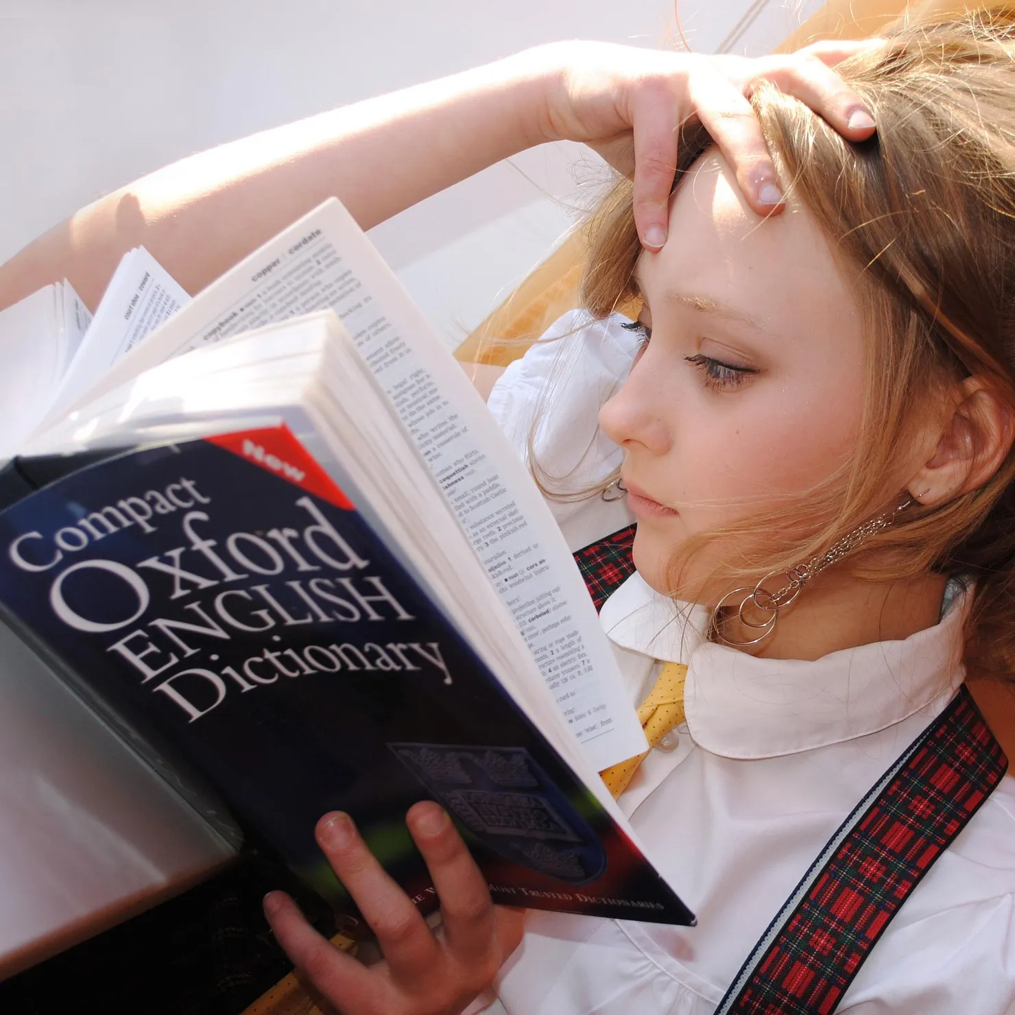 A young girl reads the Compact Oxford English Dictionary