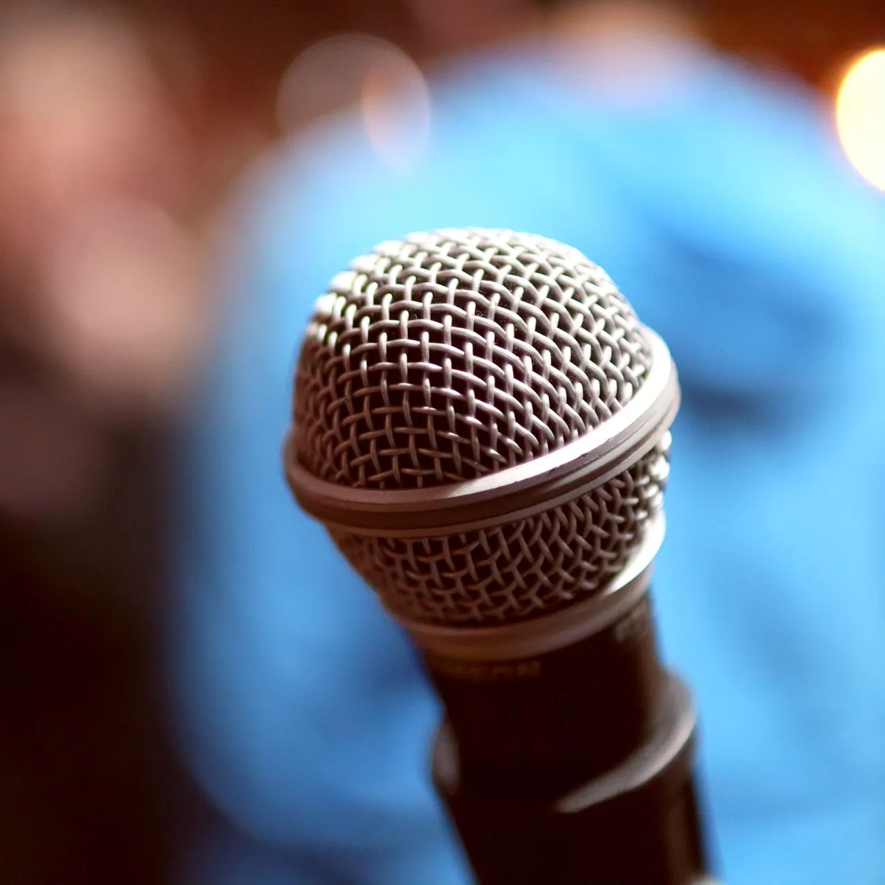 Closeup of a microphone in front of a blurred background