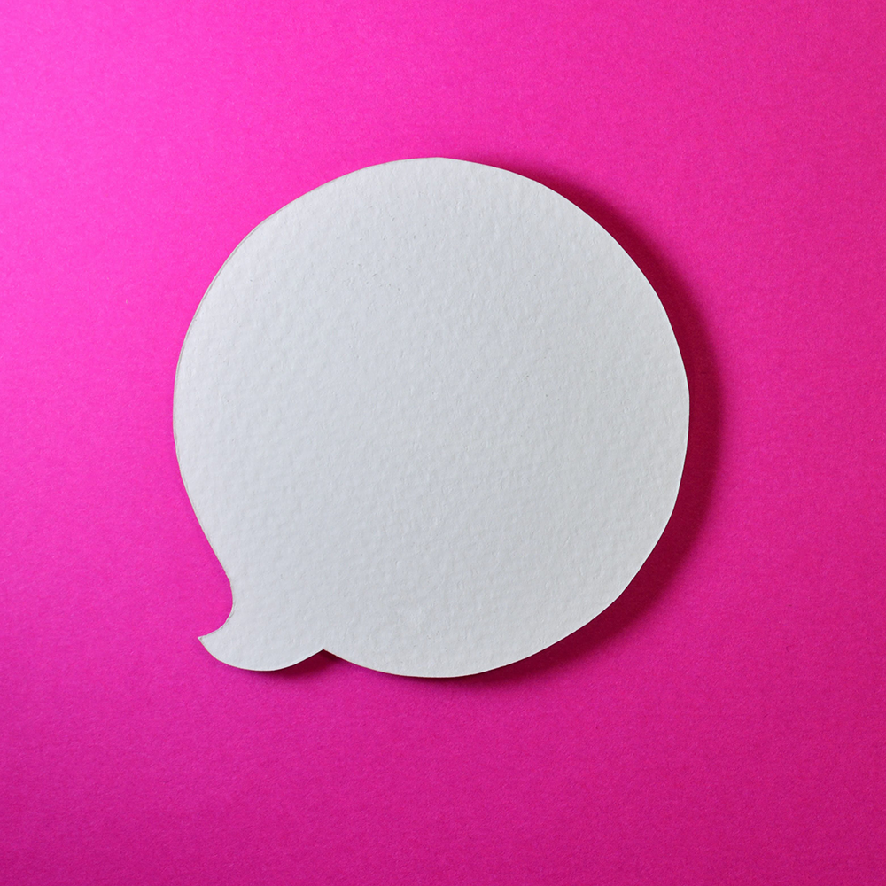 White cutout of a speech bubble on a fuchsia background