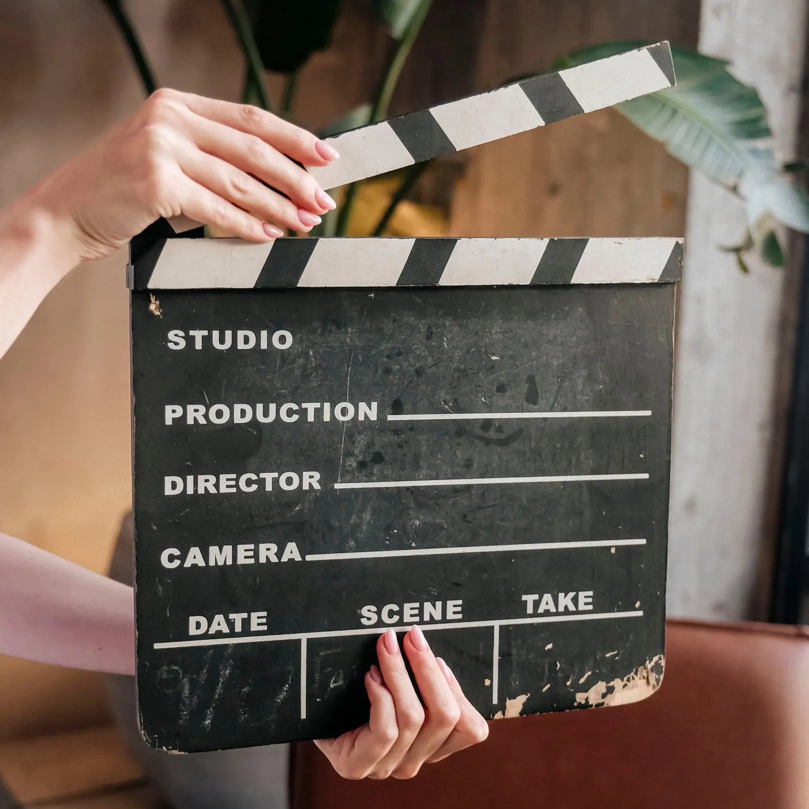 Closeup of hands holding a black and white filming clapboard