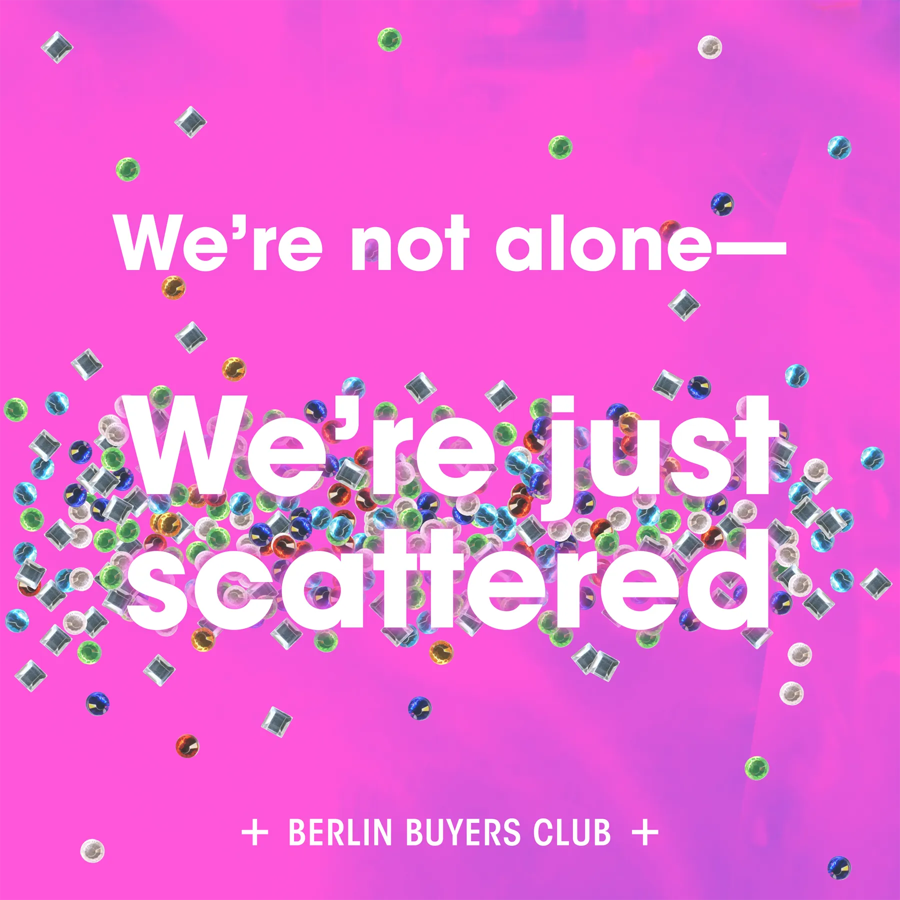 Square image with a pink textured background. Multi-coloured gems radiate from the centre and are scattered around the image. The foreground has white bolt-sans-serif text: "We're not alone—We're just scattered." The Berlin Buyers Club logo is white on the bottom.
